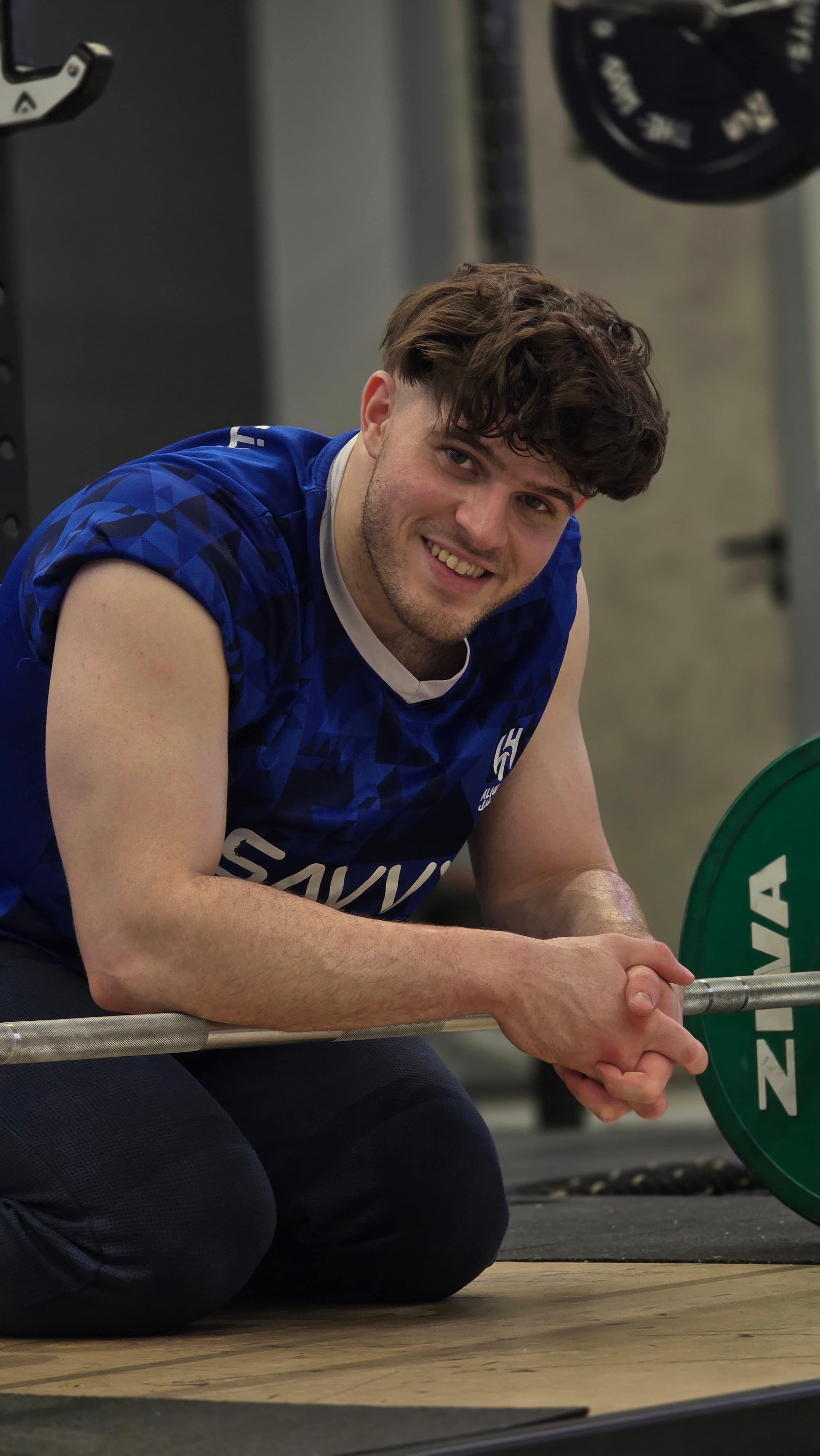 Mikael resting on a loaded barbell between sets