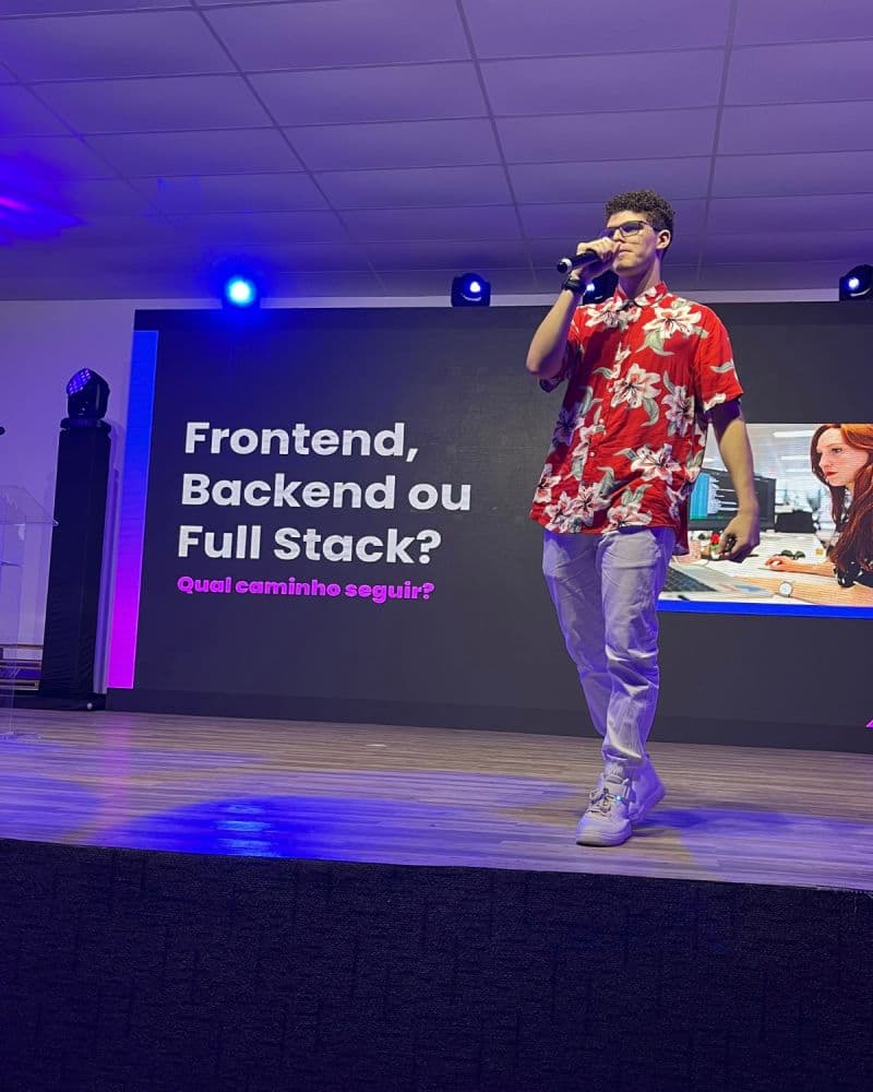 Mikael Ribeiro speaking on stage at the Rocketseat Meetup in Maceió